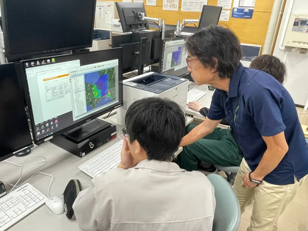 学生が画面の計算結果を見ながら指導を受けている