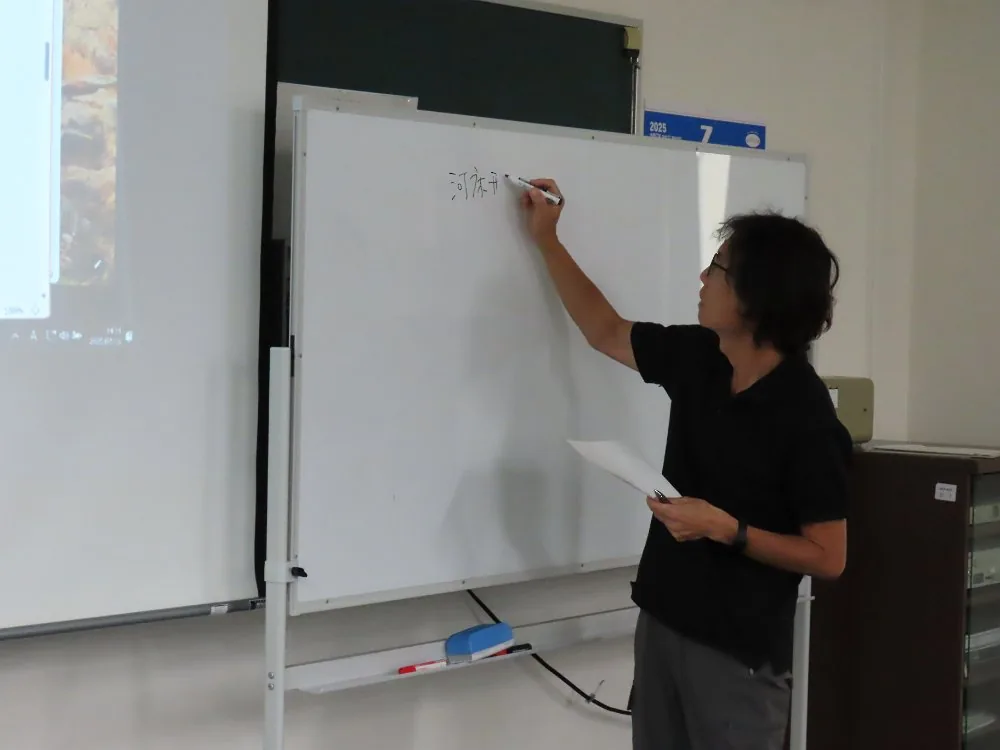 ホワイトボードに書きながら説明する講師